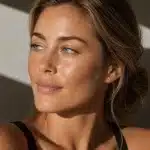 Close-up portrait of a woman with bright, clear eyes and smooth skin in natural sunlight, illustrating the refreshed look eyelid surgery can achieve