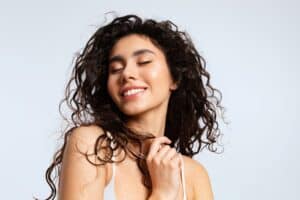 Beautiful woman with curly hair has glowing skin thanks to laser resurfacing.
