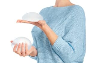 Woman holds breast implants as she considers new replacements.