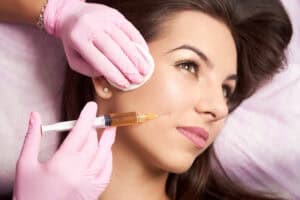 Woman gets cosmetic injection in her lower face.